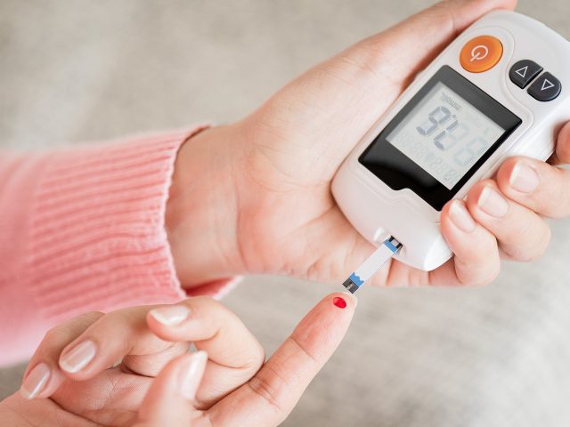 Close Up Woman Hands Checking Blood Sugar Level By Glucose Meter