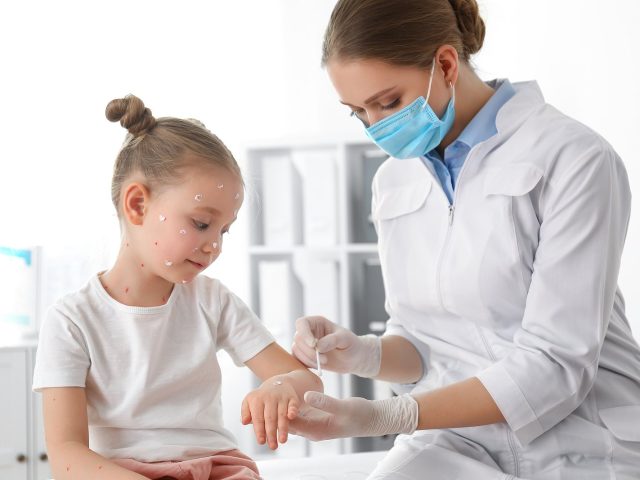 Doctor Applying Cream Onto Skin Of Little Girl With Chickenpox I